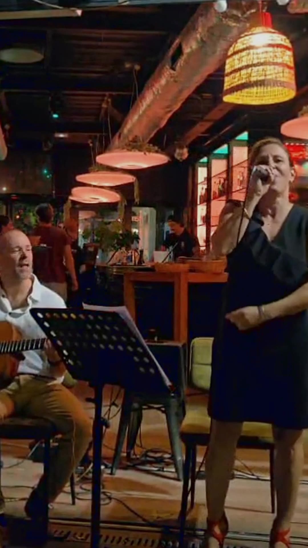 Sophie chante au micro pendant un concert de Lyre Birds
